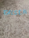 German text Ã¢â¬Å¾FALSCHÃ¢â¬Å wrong painted on asphalt road surface with vibrant bright blue paint. Concrete ground background Royalty Free Stock Photo
